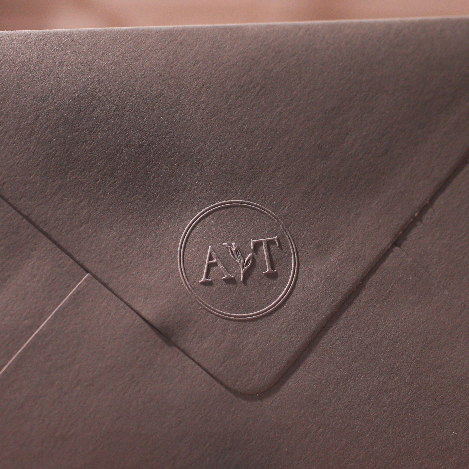 Detailaufnahme der Hochzeitsprägung „Triest" auf einem Briefumschlag – Initialen-Prägestempel